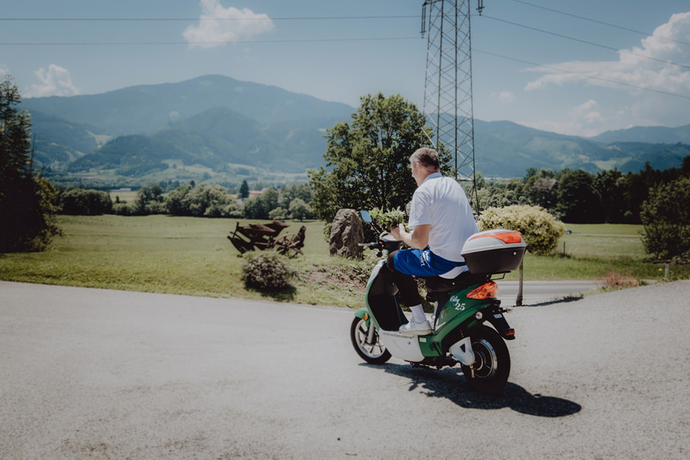 Gerald Hölzl am Weg zum Kräutergarten mit dem E-Moped